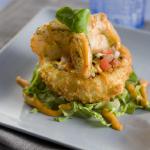 A shrimp trio appetizer on a bed of fresh local greens